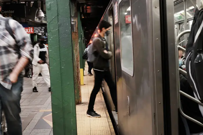 People enter a train at a Brooklyn subway station.